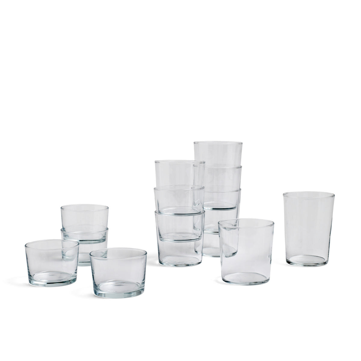 Een set van Hay Glas Helder M glazen van het merk Hay, deels als stapelbare paren en deels los gepresenteerd, op een eenvoudige witte achtergrond.