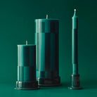 Hay Patroon Kaarsen Groen en Bordeaux (set van 4) van Hay: decoratieve kaarsen met geometrische patronen op bijpassende houders, perfect als stijlvol cadeau tegen een groene achtergrond.