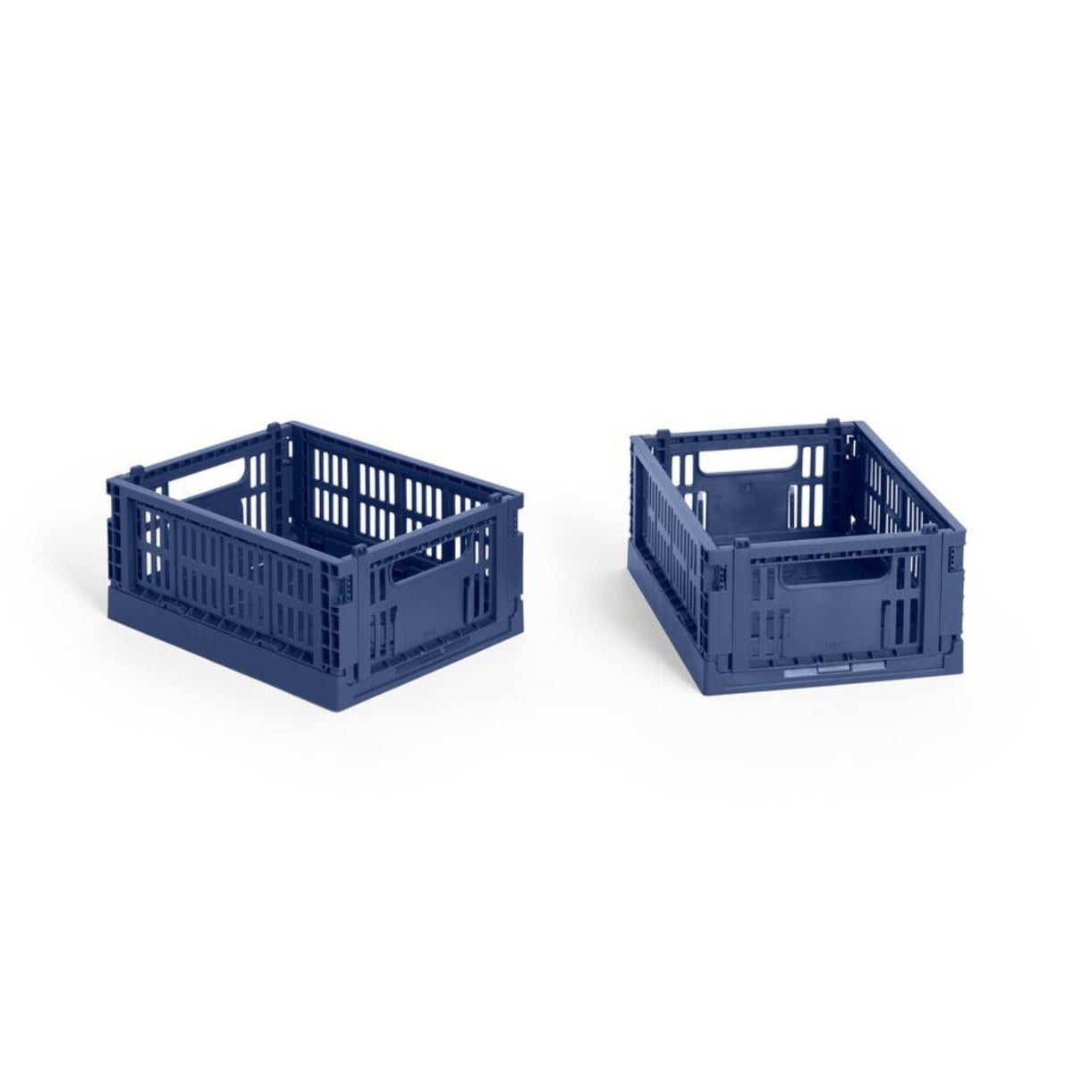 Twee Hay Kleur Krat Mini Donkerblauw opbergkratten van Hay, gemaakt van gerecycled plastic met open zijkanten en handgrepen, zijn geplaatst op een witte achtergrond - de ene schuin opzij en de andere naar voren gericht.