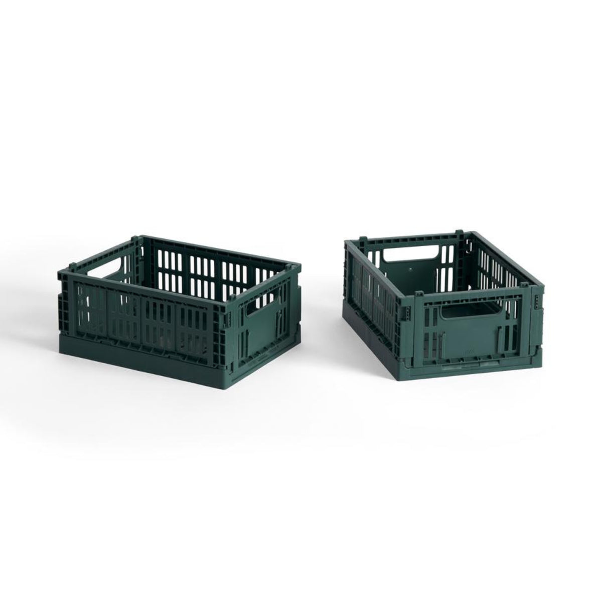 Twee Hay Kleur Krat Mini Donkergroen opbergkratten van Hay, gemaakt van gerecycled plastic met open zijkanten en handgrepen, staan naast elkaar op een witte achtergrond.