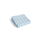 Een stapeltje Hay Pattern Papieren Servetten Lichtblauw Blauw Grid 25/25 van Hay, met een lichtblauw en blauw rasterontwerp, netjes gevouwen en gerangschikt op een witte achtergrond.