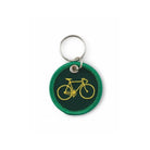 De Hightide Stitch Work Sleutelhanger Fiets is een ronde sleutelhanger van groene stof met een geel geborduurd fietsontwerp, geïnspireerd op retrostijl en bevestigd aan een metalen sleutelhanger.