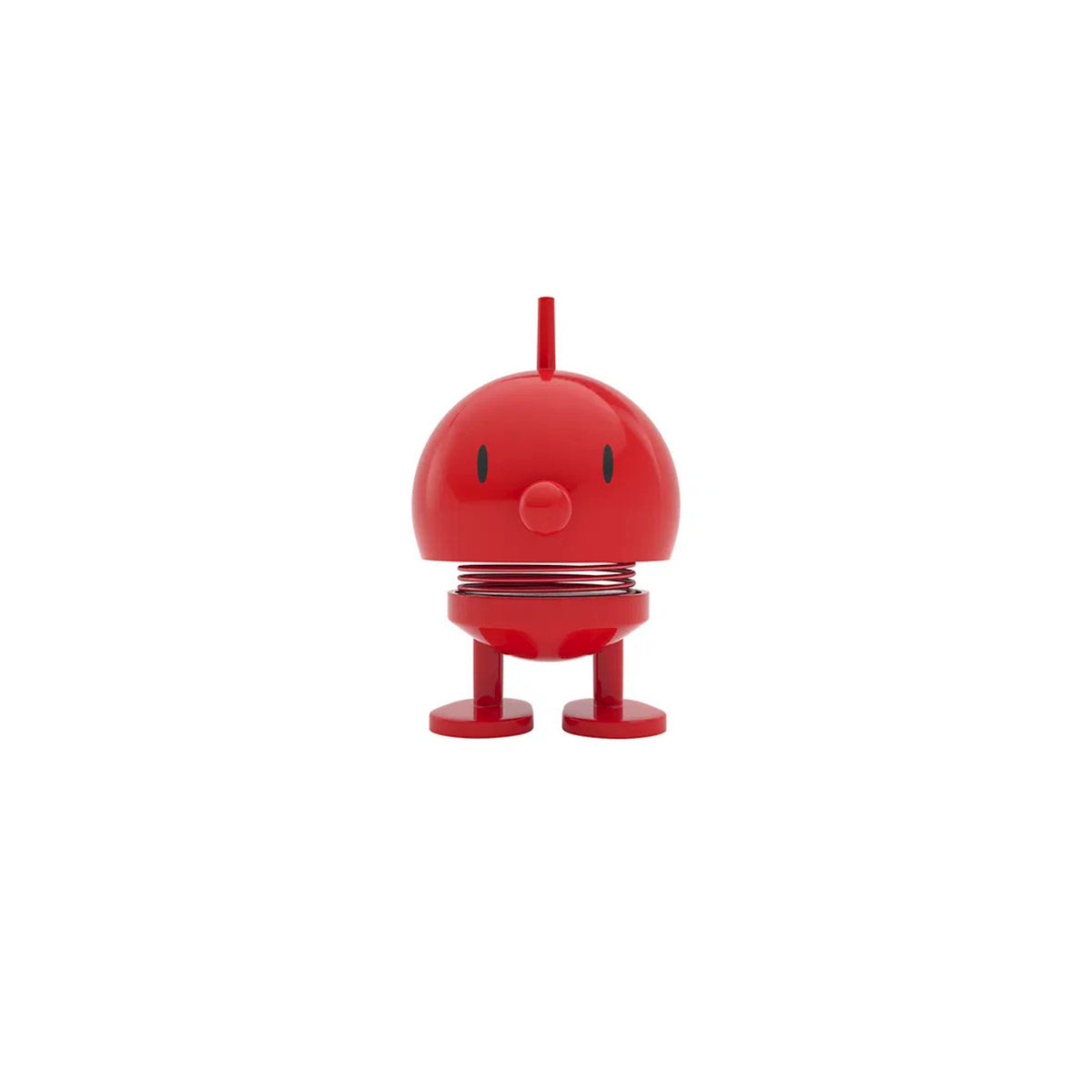 De Hoptimist Bumble S Rood van Hoptimist is een klein rood speelgoedfiguurtje met een rond hoofd, een verende nek en ovale ogen, staand op twee platte voetjes - een prachtig Deens designobject tegen een witte achtergrond.