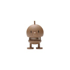 De Hoptimist Soft Bumble S Chocolate, een klein bruin rond figuurtje van Hoptimist met een eenvoudig gezichtje, snavelachtige neus, puntoogjes, veerkrachtig lichaam en korte beentjes met platte voetjes staat tegen een effen witte achtergrond-een charmant voorbeeld van Deens design.