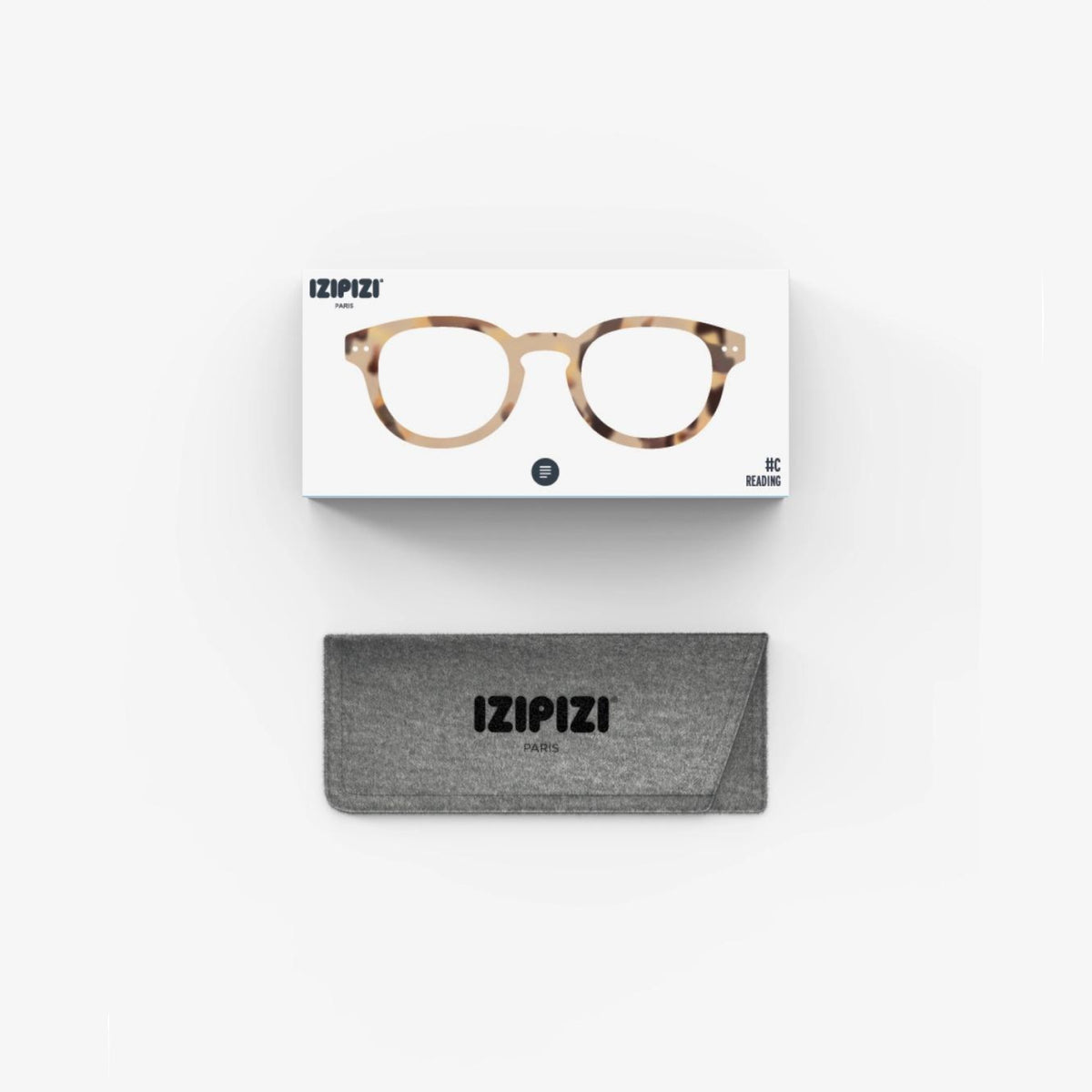 Een Izipizi Leesbril #C Light Tortoise zit in zijn doosje boven een grijze stoffen Izipizi-koker, tegen een effen witte achtergrond.