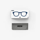 Een wit doosje met een blauwe brilillustratie en het merk Izipizi zit boven een grijs stoffen Izipizi leesbrildoosje, beide weergegeven op een witte achtergrond. Product: Izipizi Leesbril #C Navy.