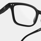 Close-up van de Izipizi Leesbril #L Zwart van Izipizi-zwarte rechthoekige leesbril met heldere glazen, gedetailleerd montuur en LEESbril op de arm; perfect als leesbril voor presbyopie en qua stijl vergelijkbaar met andere brillen van Izipizi.