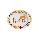 De &Klevering Haines Schotel 28/22 van &Klevering is een charmante ovale porseleinen schaal met kleurrijke herfstmotieven, zoals sinaasappelbomen, een ladder, sokken aan een waslijn, appels, bessen en vallende bladeren - in geschenkverpakking.