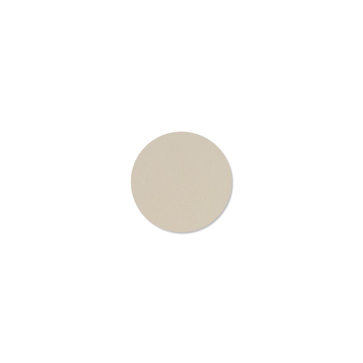 Een kleine, lichtbeige cirkel met een textuur van gerecycled leer is gecentreerd op een effen witte achtergrond en weerspiegelt de kalme elegantie van de Lind DNA Serene Onderzetter Rond Crème D10.