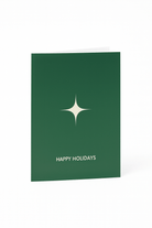 De Matriks Kerst- en Nieuwjaarskaart Happy Holidays is een groene kaart van Matriks met een eenvoudige witte ster boven vetgedrukte witte "HAPPY HOLIDAYS" tekst in het midden.