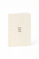 De Matriks Nieuwjaarskaart Happy New Year! van Matriks is een crèmekleurige kaart met gouden en bruine confetti-achtige stippen en lijnen, met "HAPPY NEW YEAR!" in het midden.