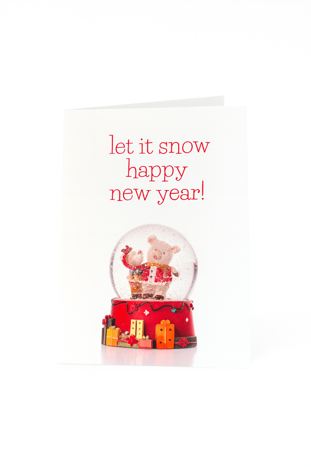 Verspreid vakantievreugde met de Matriks Nieuwjaarskaart Laat het sneeuwen Gelukkig Nieuwjaar! Op deze unieke kaart staat een sneeuwbol met een varken tussen cadeautjes en de boodschap "let it snow happy new year!" in rood op wit. Van Matriks.