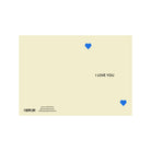 De Matriks JL Postkaart I Love You Dubbel van Matriks is een crèmekleurige kaart met twee kleine blauwe hartjes in tegenoverliggende hoeken en "I LOVE YOU" in zwart rechts in het midden. Linksonder staan de barcode en contactgegevens.