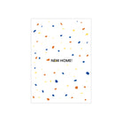 Op de Matriks JL Postkaart New Home White Dubbel van Matriks staat "NEW HOME!" in het midden, geaccentueerd met blauwe, oranje en gele confetti op een witte achtergrond.