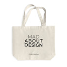De Matriks Mad About Design Tote Bag van Matriks is een beige canvas tas van duurzaam materiaal, met "MAD ABOUT DESIGN" in zwart en mitriks.com eronder - een must-have voor elke designliefhebber, afgebeeld op een witte achtergrond.