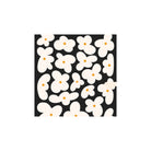 PPD Papieren Servetten Bloemen Zwart 33/33 van PPD hebben een dicht patroon van crèmekleurige bloemen met oranje harten op een zwarte achtergrond. Eén bloem overlapt lichtjes de rechterrand. Gemaakt van 3-laags FSC-gecertificeerd papier.