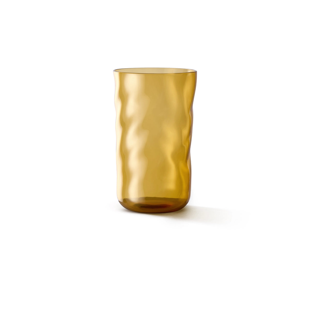 De Paveau Swirl Longdrink Glas Dune Geel 46 cl van Paveau is een hoog cilindrisch amberkleurig glas met een golvend, gestructureerd oppervlak, tegen een effen witte achtergrond.