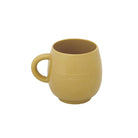 Een beige keramische Penco Mok van Penco heeft een gebogen lichaam, ronde voet, handvat aan de linkerkant en "penco" in reliëf op de zijkant. Deze retro mok is geïnspireerd op Japans design en wordt weergegeven tegen een effen witte achtergrond.