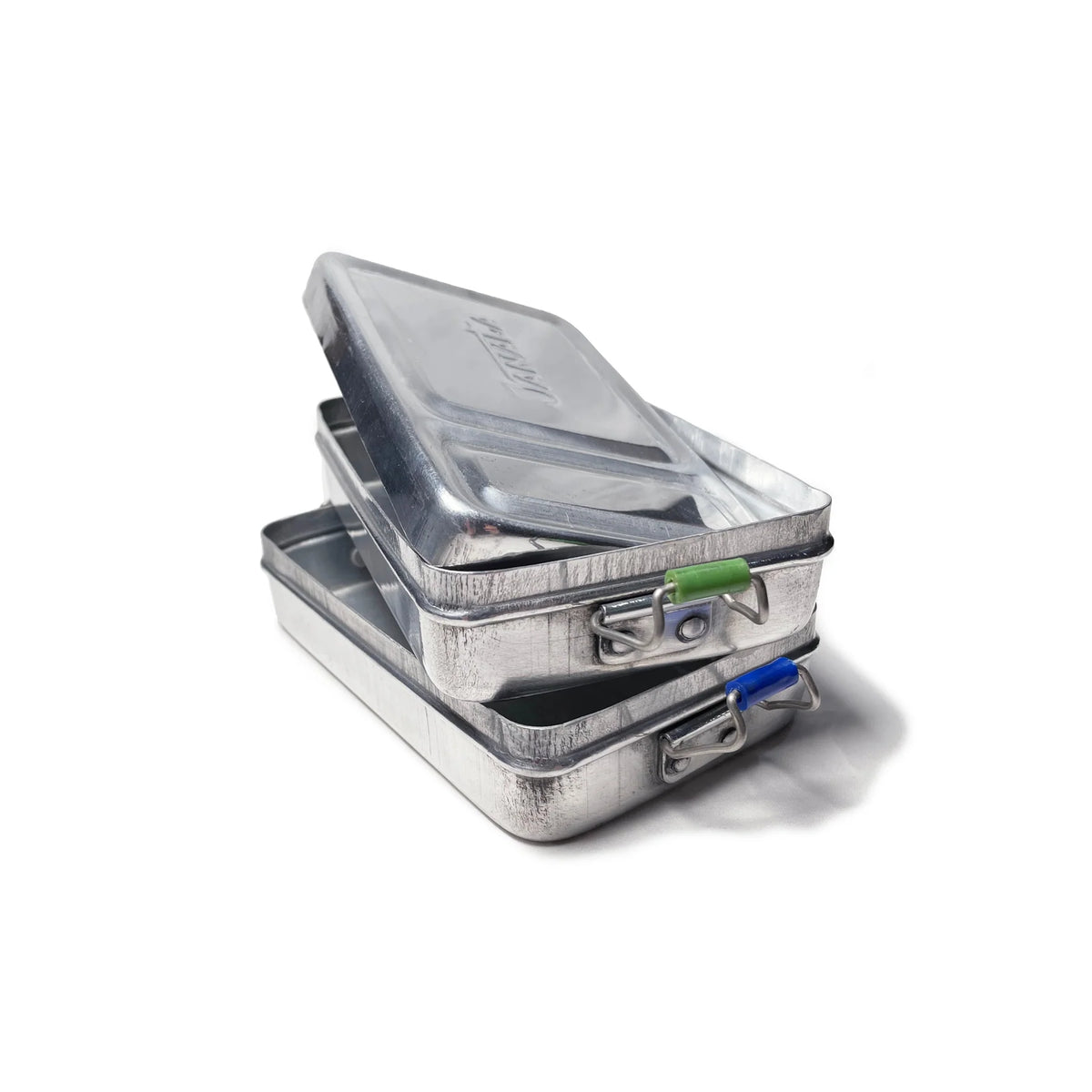 Twee rechthoekige Puebco Aluminium Lunchboxen, elk met een doorzichtig deksel en metalen sluitingen - een groene, een blauwe - zijn gestapeld tegen een witte achtergrond voor een industriële look.