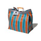 De Puebco Gerecycleerde Tas Strepen Oranje Blauw Vierkant is een grote tas met blauwe, oranje en witte verticale strepen, oranje plastic handvatten en een bagagelabel (5053172), gemaakt van gerecycled plastic door Puebco.