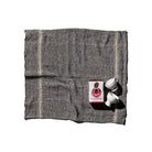 De Puebco India Theedoek Grijs 60/60 van Puebco, vervaardigd uit gerecycleerde stoffen, vormt het decor voor twee witte koffiekopjes en een rood-witte Counter Culture Coffee verpakking tegen een witte achtergrond.