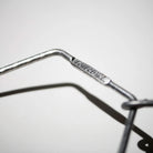 Close-up van een metalen Puebco Keukenrolhouder Hanger, met "CHEEGO INC." erop gegraveerd. De scherpe focus benadrukt de gravure, terwijl de achtergrond wazig lijkt. Merk: Puebco.