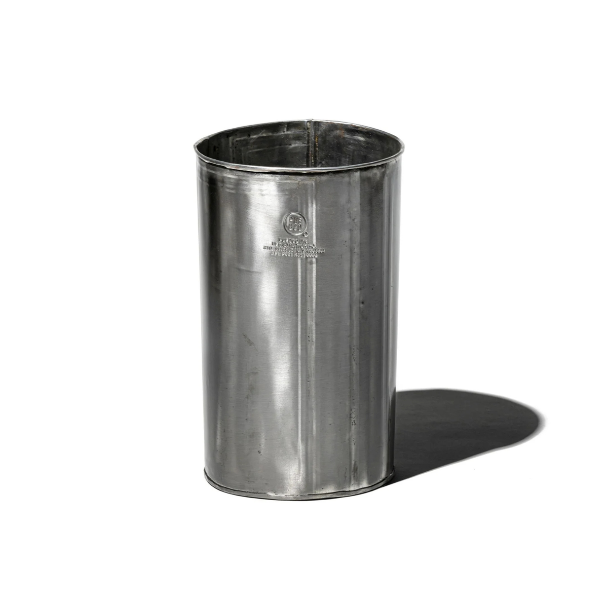De Puebco Prullenbak Gerecycleerd Staal H28 van Puebco is een hoge, cilindervormige afvalbak van gerecycled staal met een glad, glanzend oppervlak. Hij staat rechtop op een witte achtergrond en werpt een zachte schaduw naar rechts.