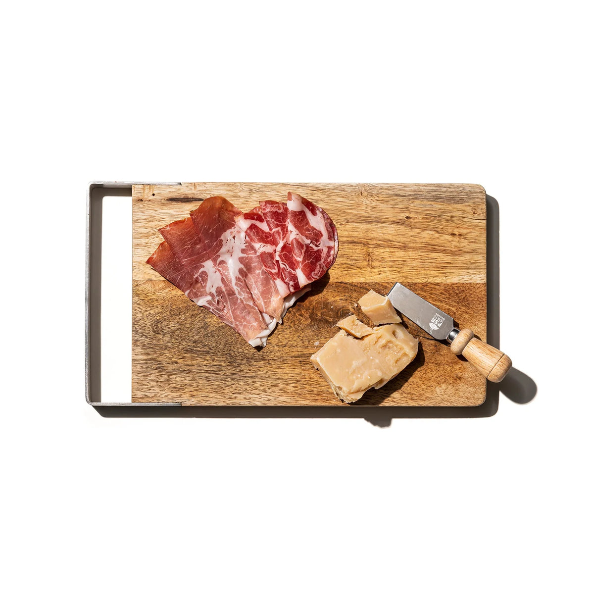 Plakjes gerookt vlees en stukjes harde kaas geserveerd op de Puebco Snijplank Mango Hout 20/32 met een klein kaasmes met een stalen handvat, alles tegen een witte achtergrond.