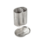 Een niervormige metalen bak met twee vakken en een bijpassend deksel dat ervoor is geplaatst op een witte achtergrond, die doet denken aan het elegante ontwerp van de Serax Surface Wijnkoeler van Serax.