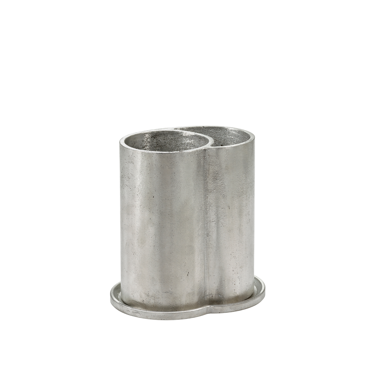 De Surface Wijnkoeler, vervaardigd door Serax, heeft een zilverkleurige metalen behuizing met twee cilindervormige compartimenten die op een gemeenschappelijke voet zijn bevestigd, ideaal voor het opbergen van bijvoorbeeld pennen of bestek. Het subtiel gestructureerde oppervlak en de strakke lijnen doen denken aan de kenmerkende esthetiek van Sergio Herman in zijn ontwerpen voor Serax, met name de aluminium wijnkoeler uit de Surface-collectie.