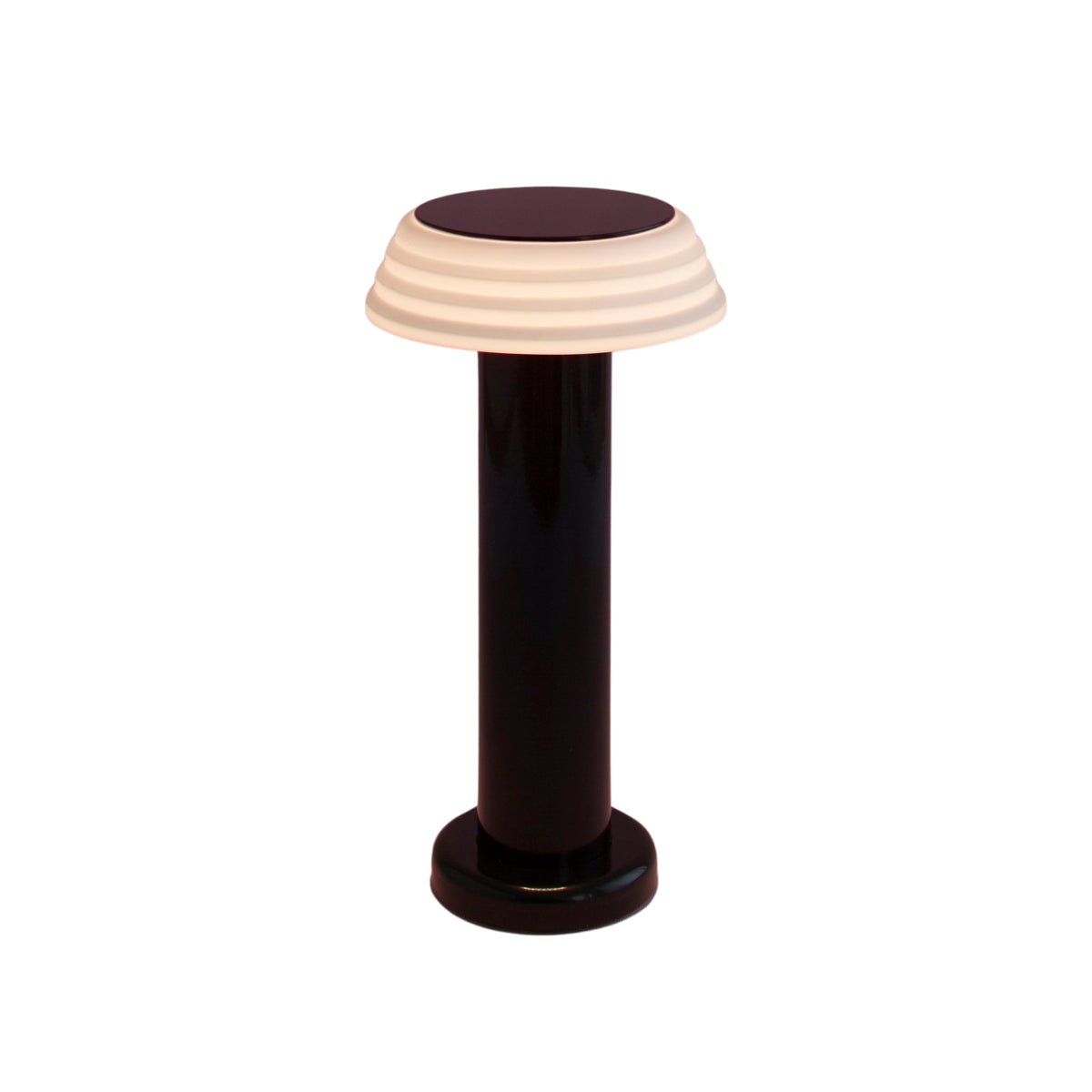 De Sowden PL1 Lamp LED Oplaadbaar Zwart van Sowden heeft een zwarte cilindrische voet en een witte, geribbelde koepelvormige kap en biedt een minimalistisch, eigentijds ontwerp geïnspireerd door de Memphis Design Movement.