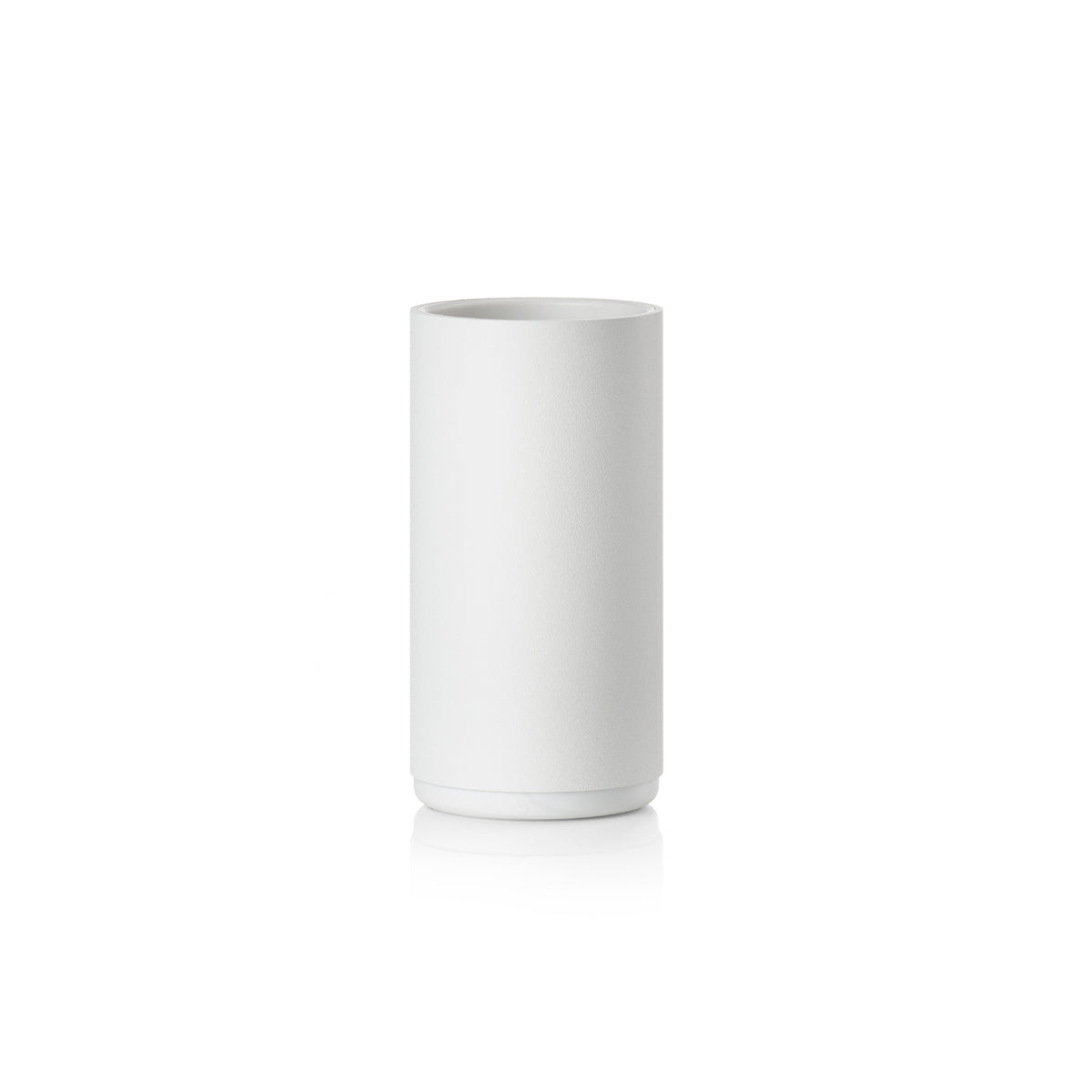 Een eenvoudige, cilindervormige beker van wit keramiek staat rechtop op een witte achtergrond met een subtiele reflectie eronder-perfect als de Zone Denmark Rim Tandenborstelhouder Wit voor het organiseren van je badkamerbenodigdheden.