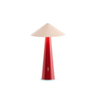 De Fine Lumens Tipsy Lamp LED Oplaadbaar van Fine Lumens heeft een poederroze en donkerrode kegelvormige voet met een brede beige kegelvormige kap, gefotografeerd op een effen witte achtergrond.