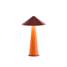 De Fine Lumens Tipsy Lamp LED Oplaadbaar Rustiek in Rood Oranje heeft een dimbare, kegelvormige glanzend oranje lampvoet en een brede kastanjebruine kap, die een warme gloed verspreidt. Deze draadloze lamp van Fine Lumens wordt getoond verlicht op een witte achtergrond.