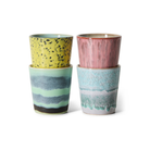 Twee stapels HK Living 70s Ceramics Koffiemok kopjes: linker stapel is geel met zwarte spikkels over groen met blauwe strepen; rechter stapel is roze over turkoois met golvende patronen. Verkocht als set van 4 door HK Living.