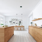 Moderne keuken en eethoek met lichthouten kasten en een minimale inrichting. De Jacob Jensen Optische Rookmelder Groen D10 voegt discrete veiligheid toe en past naadloos in het Scandinavische ontwerp voor een frisse, luchtige uitstraling.