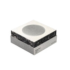 De Jacob Jensen Optical Rookmelder Zilver D10 heeft een Scandinavisch ontwerp, met een vierkante vorm, een slanke witte en grijze verpakking en een ronde sensor van zilvergaas bovenop, tegen een effen witte achtergrond.